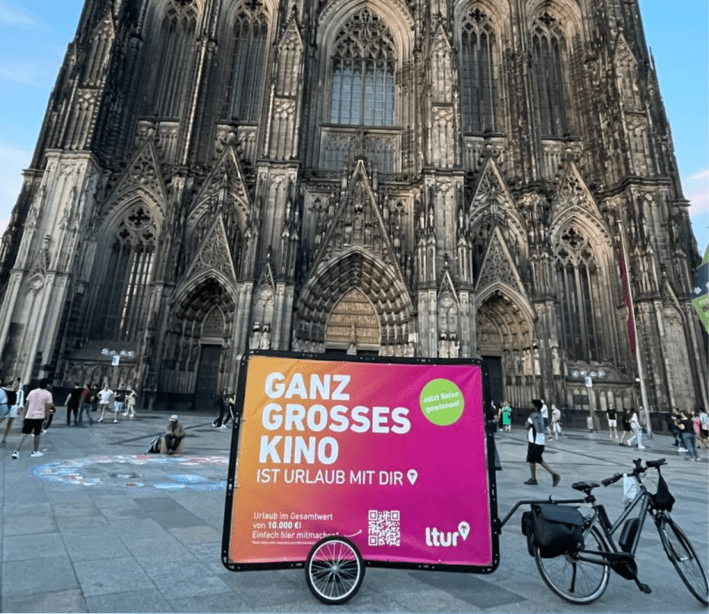 Mobile Außenwerbung in Köln vor dem Wahrzeichen der Stadt